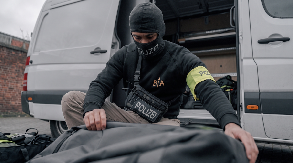 A man looking like a German police officer getting ready for a mission.