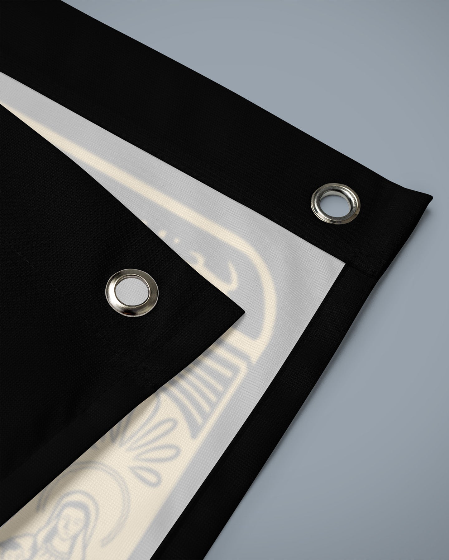 Black fabric with grommets on a gray background - No Fear Flag