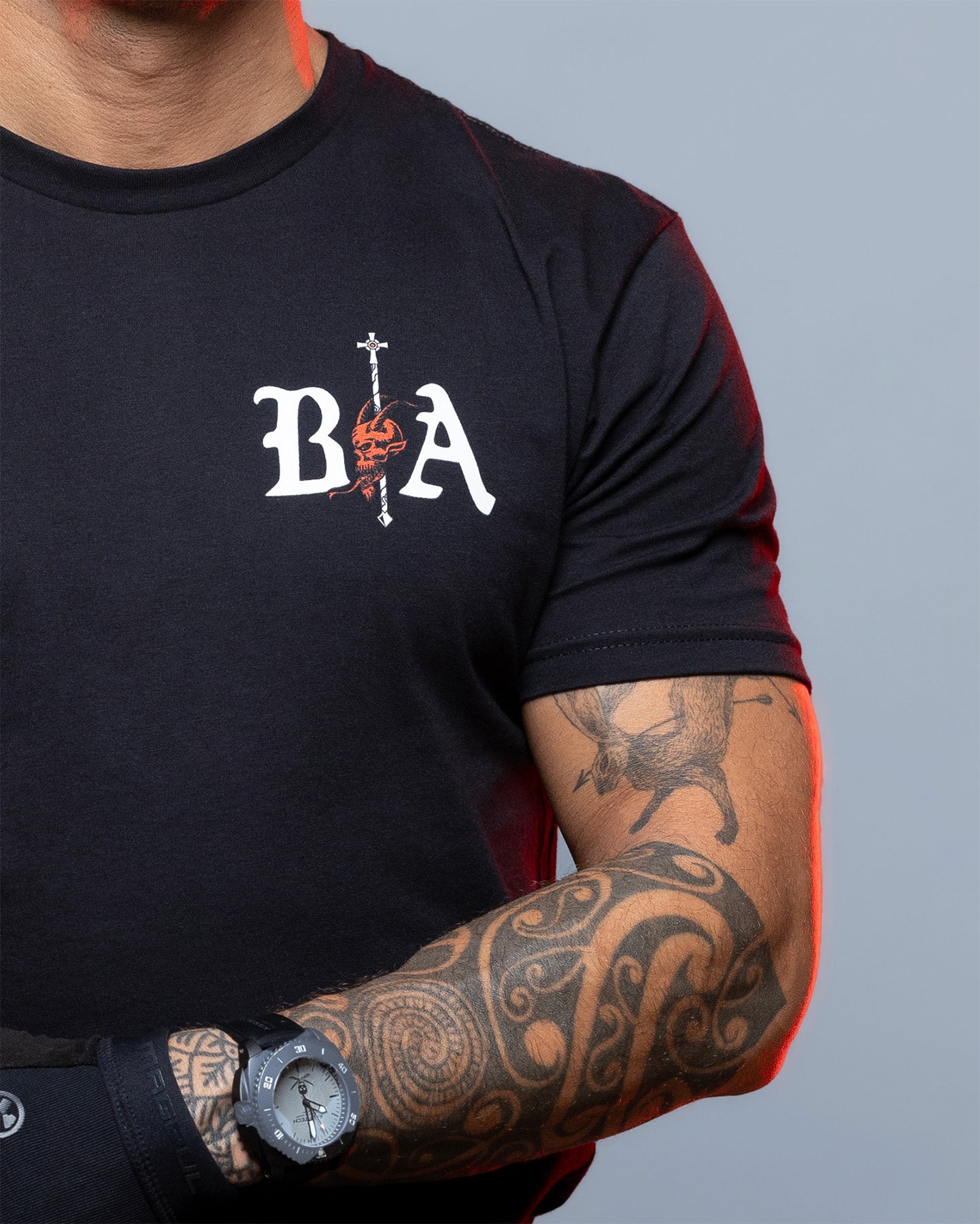 Person wearing a black t-shirt with a logo on a gray background #color_black