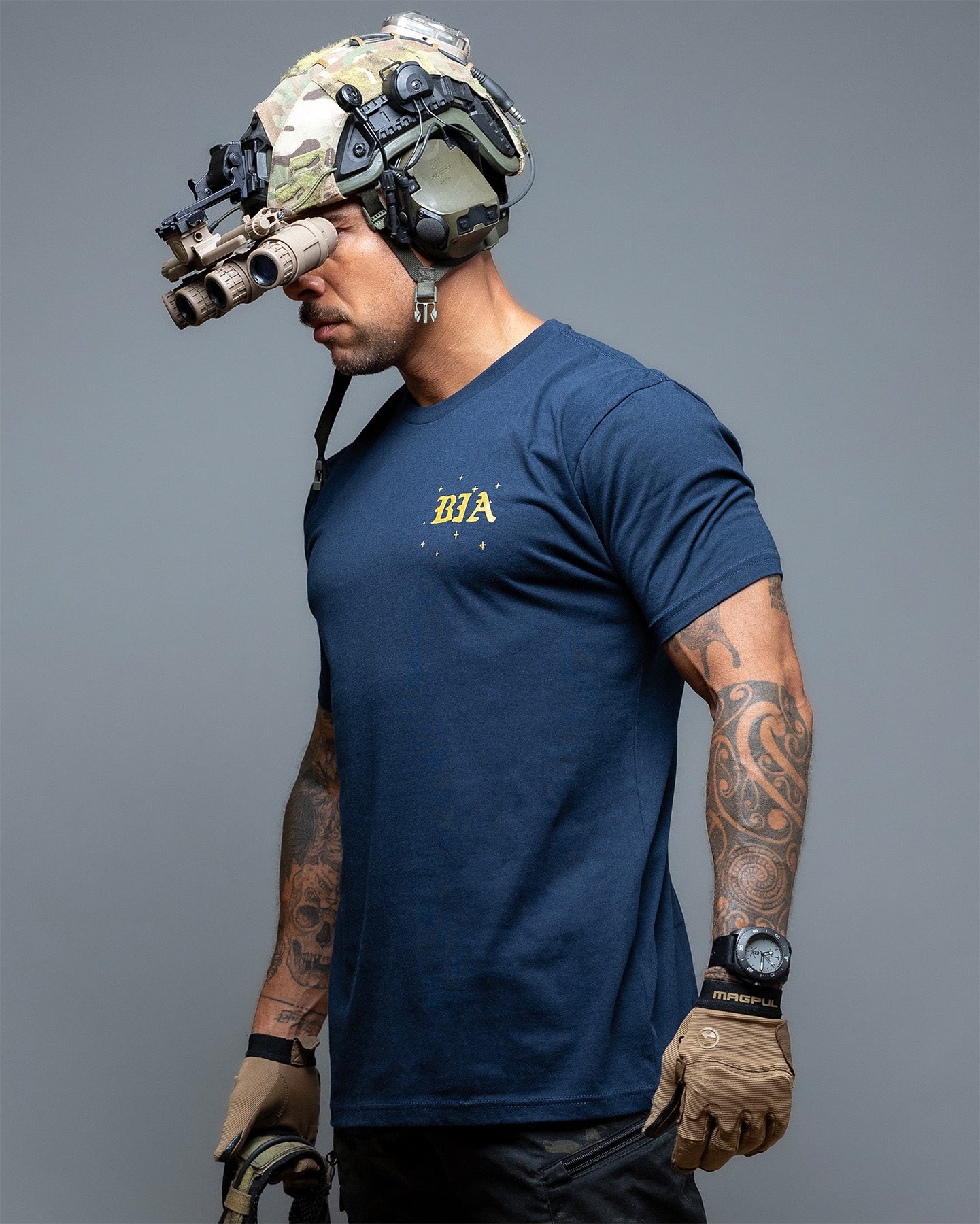 Person wearing a navy blue t-shirt with 'BIA' logo, tactical helmet, and gloves on a gray background. #color_navy