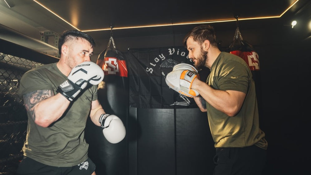 Two men practicing self-defense in a Brothers in Arms outfit