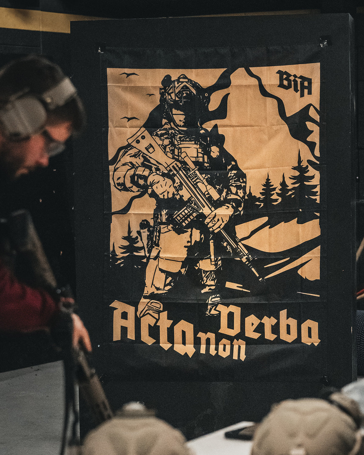 Acta Non Verba flag hanging on the wall of an indoor shooting range