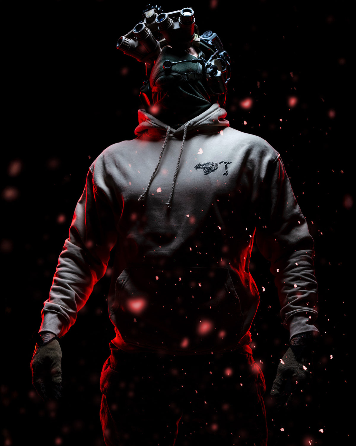 Man in a gas mask wearing the sand Air Assault Hoodie, red sparks in the dark