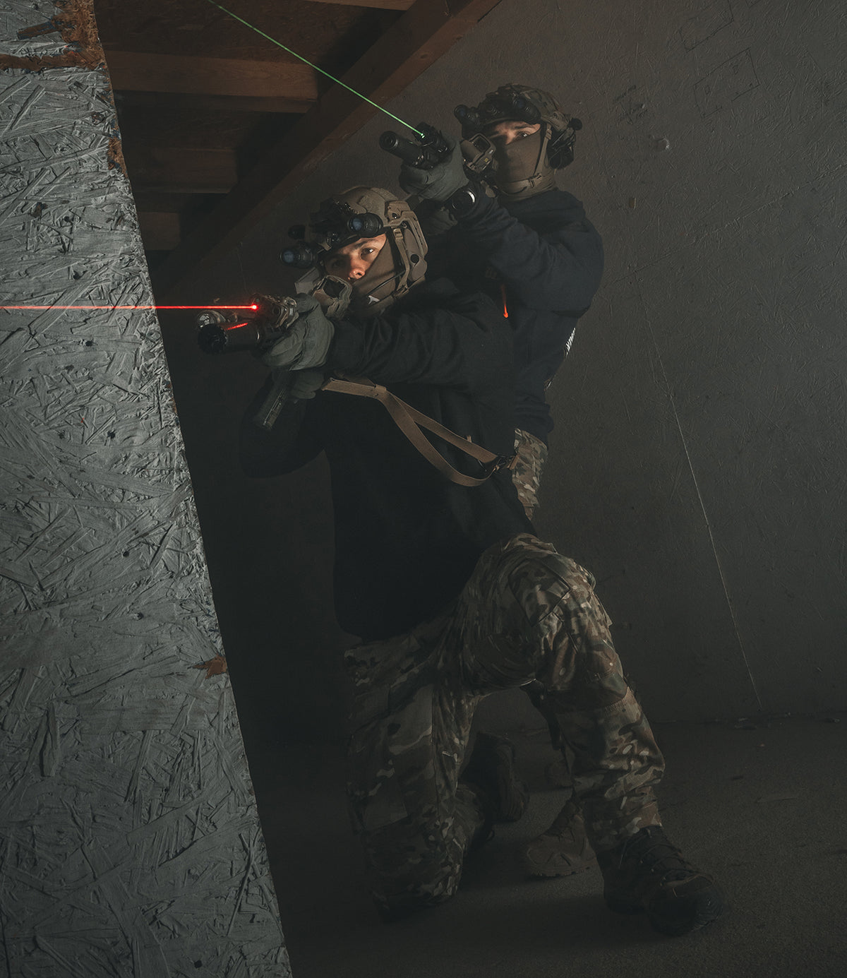 Two operators stacked at a wall during close quarters training, weapons up
