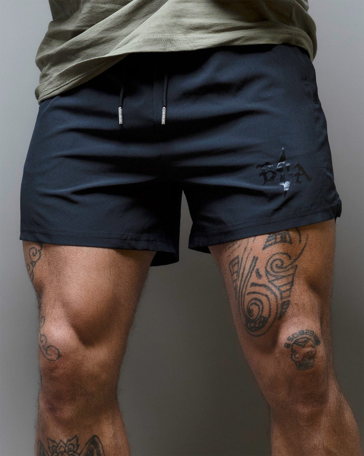 Man wearing the dark Bolt gym shorts, front view