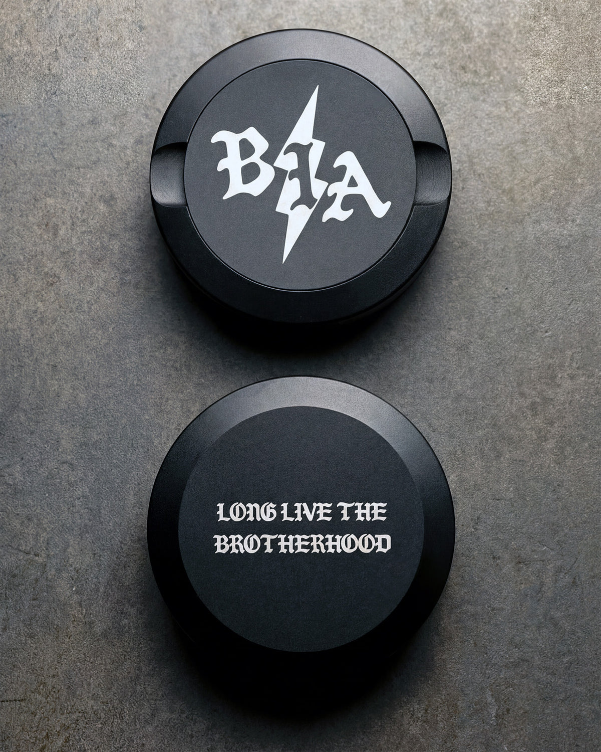 Two Bolt pouch cans stacked, one with the BIA logo, one with the Brotherhood engraving