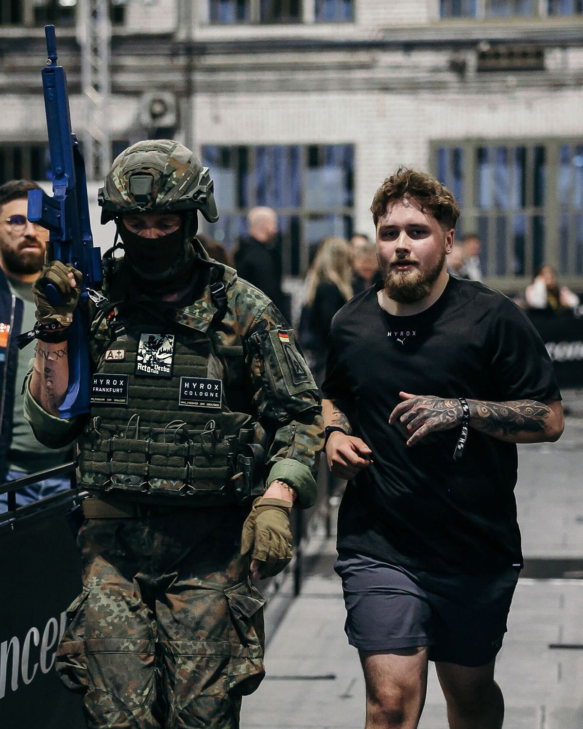 Soldiers in gear during a training run, one wearing the Acta Non Verba patch