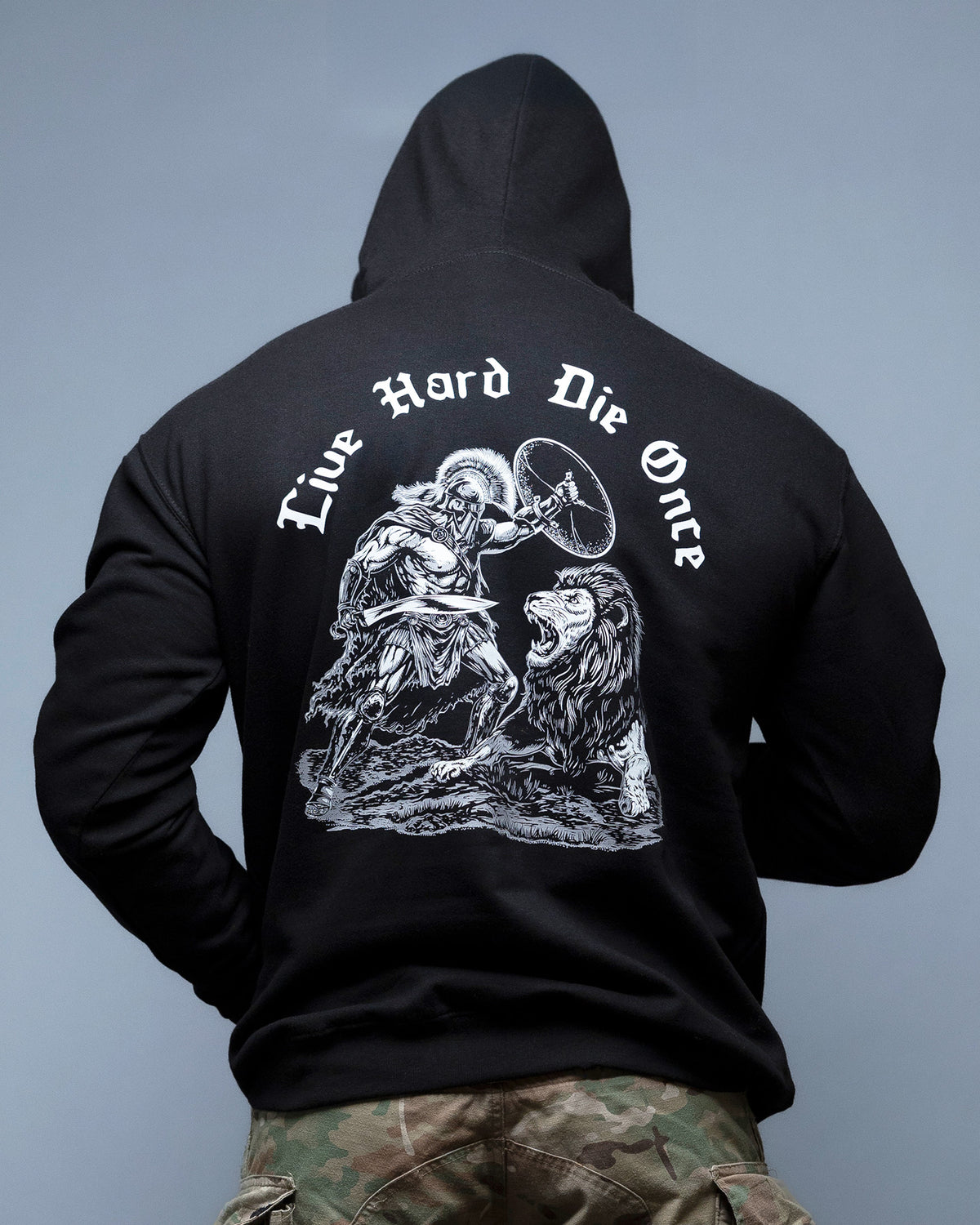 Man from behind in the black Live Hard Die Once Hoodie with the reaper and lion back print