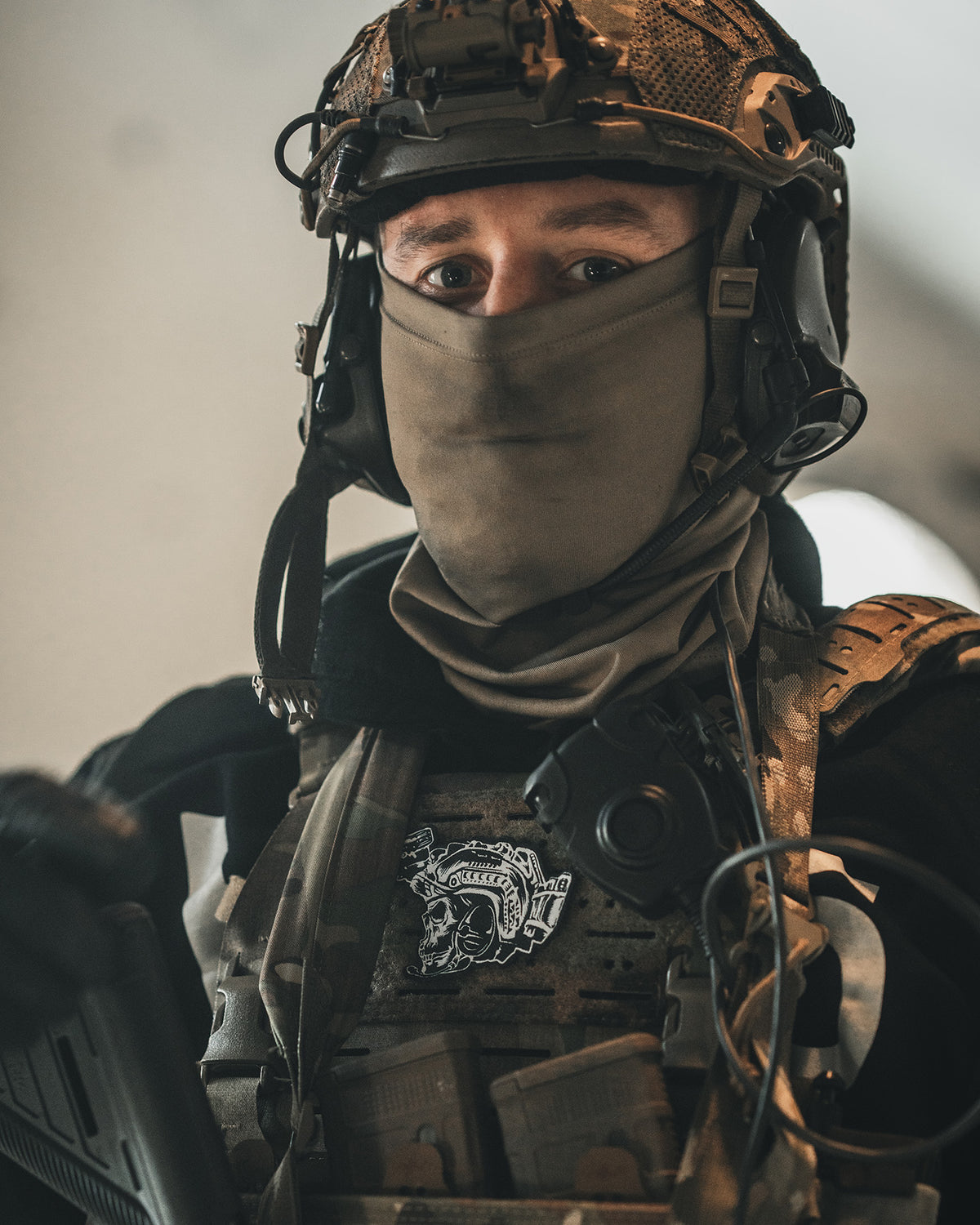 Soldier with helmet and face mask, the Team patch on his plate carrier