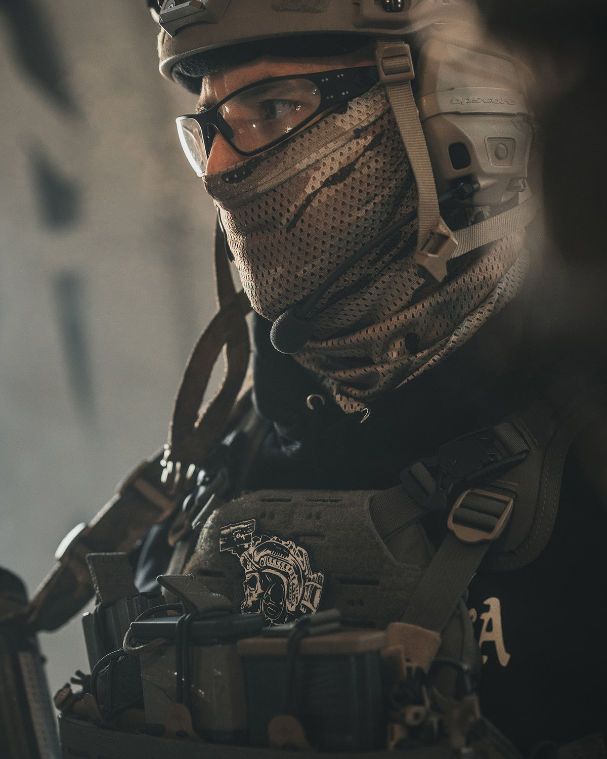 Soldier with helmet and mesh face mask, the Team patch on his kit