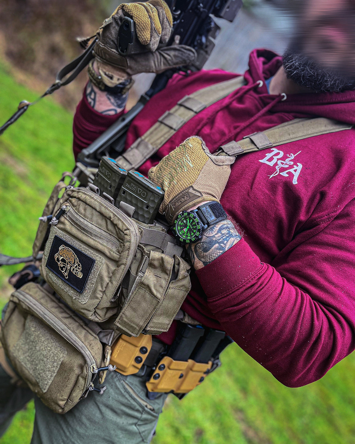 Close-up of a chest rig worn over the bordeaux St. Michael Hoodie