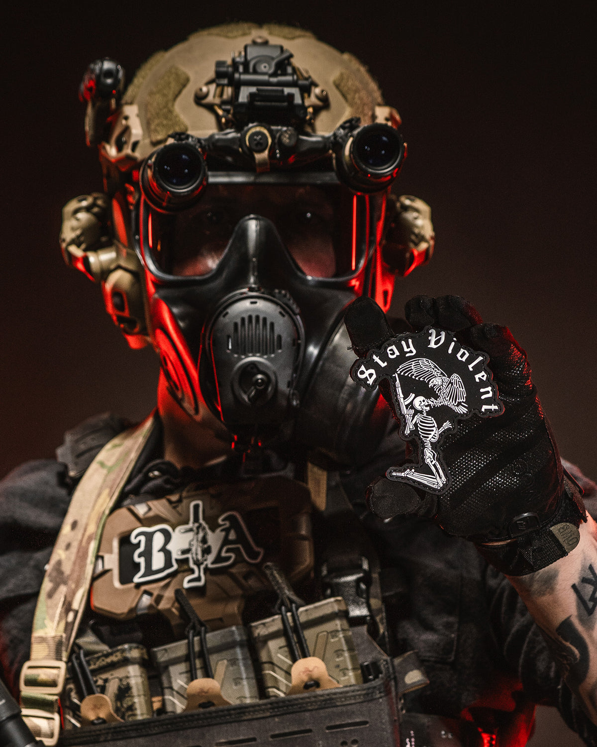 Operator in a gas mask with the Stay Violent 3D patch on his chest rig