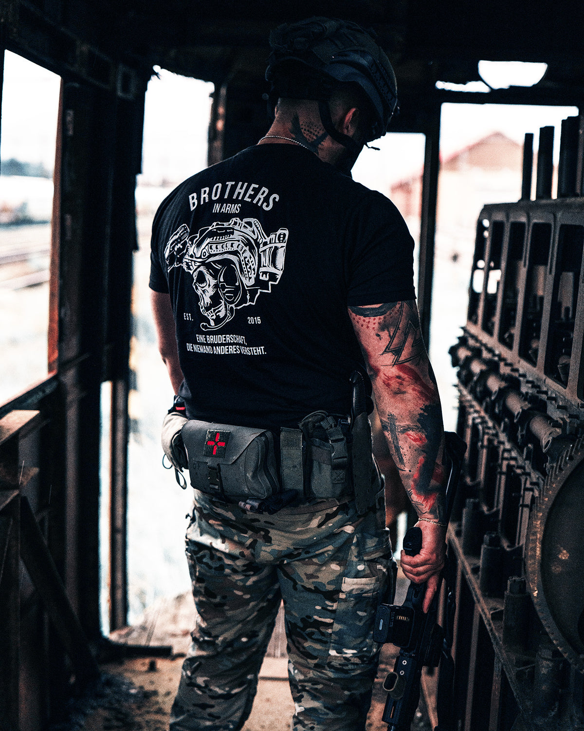 Man from behind in the black Team T-Shirt in an abandoned industrial building