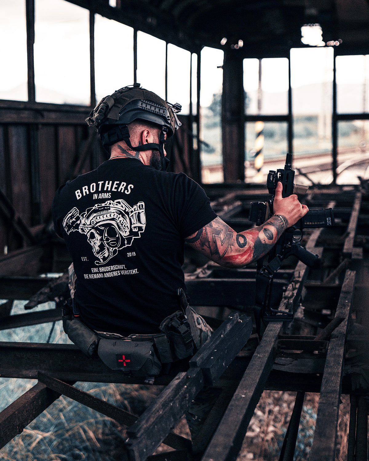 Man with a pistol wearing the black Team T-Shirt in an abandoned building