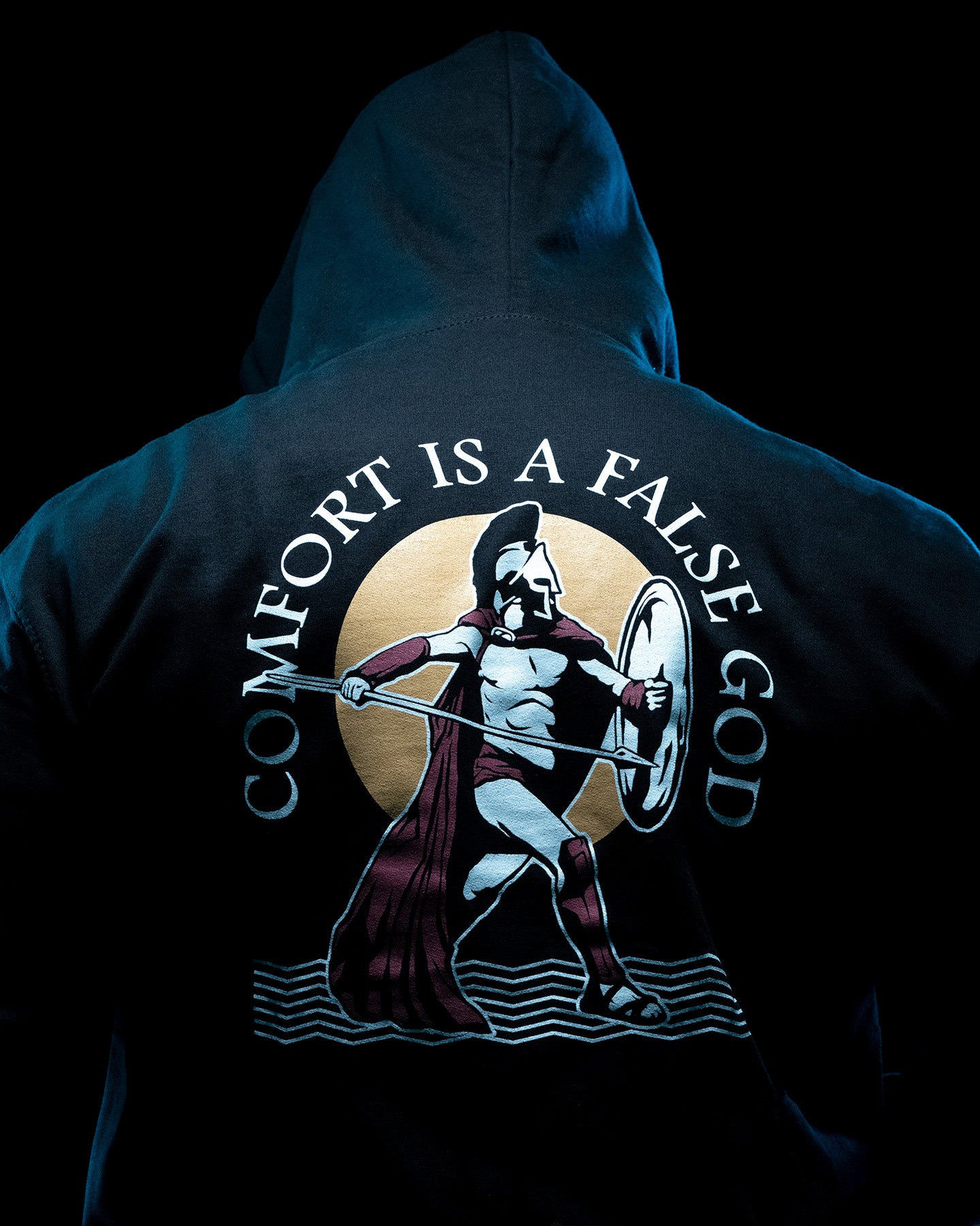 Close-up from behind of the Spartan back print on the black Comfort Is A False God Hoodie #color_black #in_field