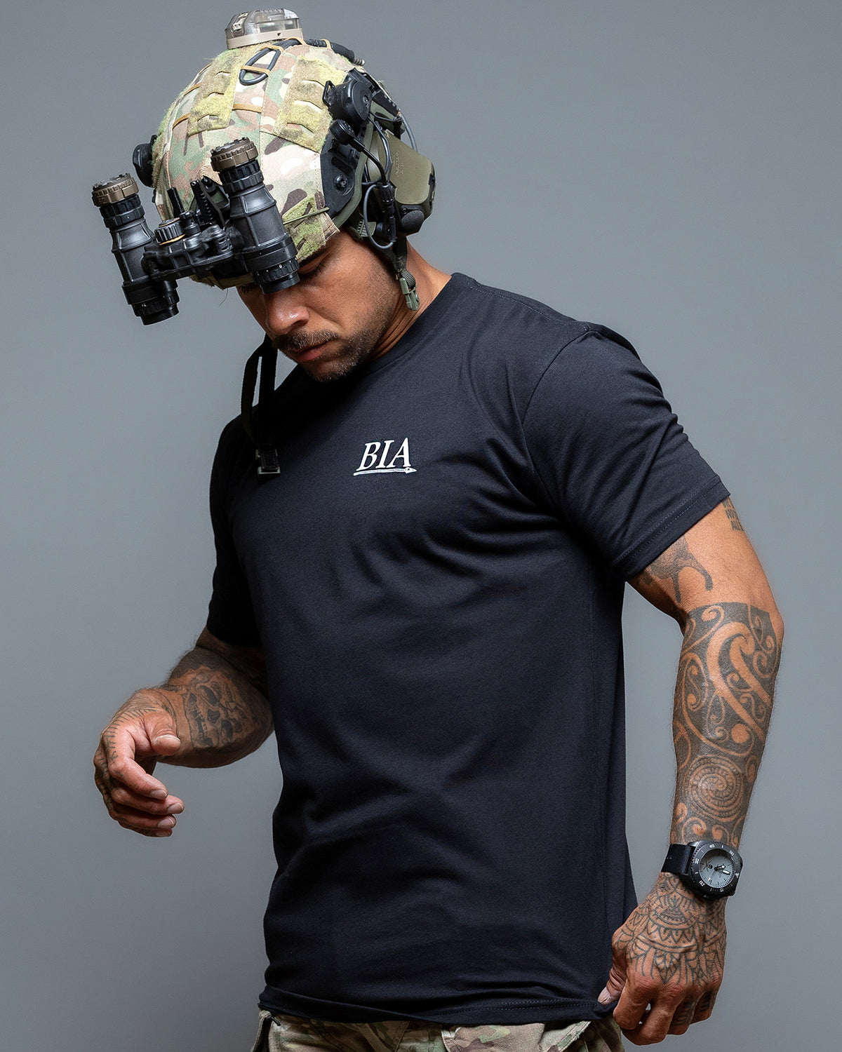 Man with helmet and night vision wearing the black Comfort Is A False God T-Shirt