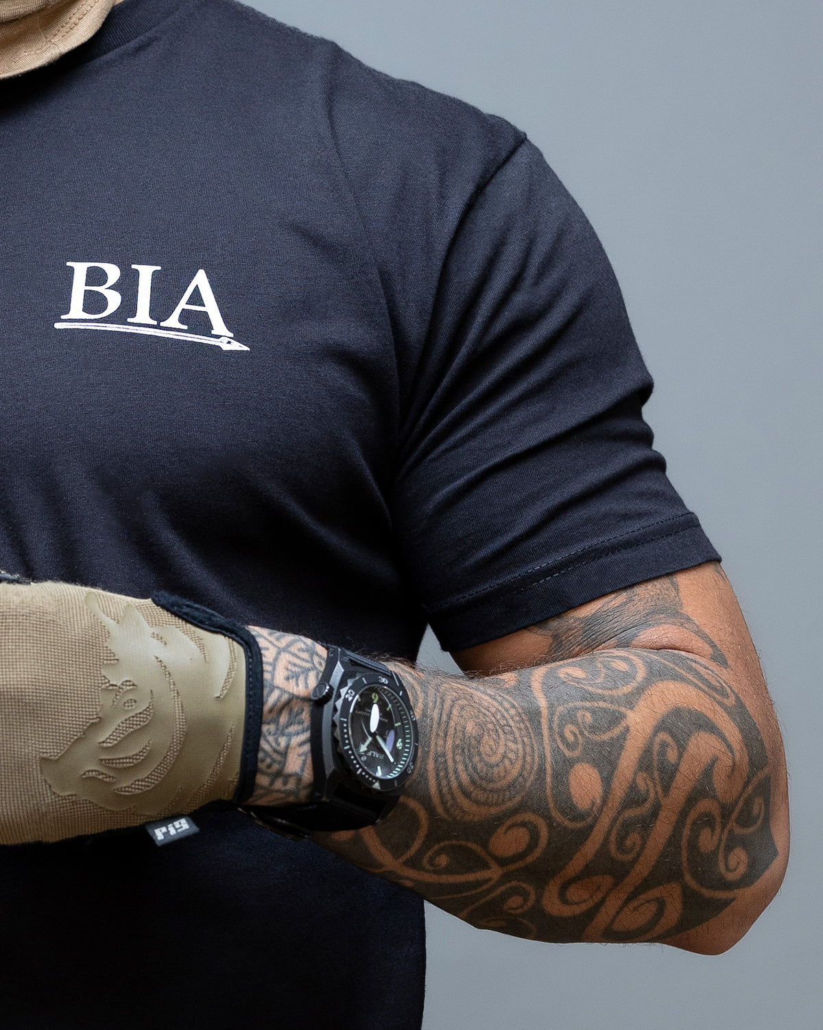 Close-up of the BIA chest print on the black Comfort Is A False God T-Shirt