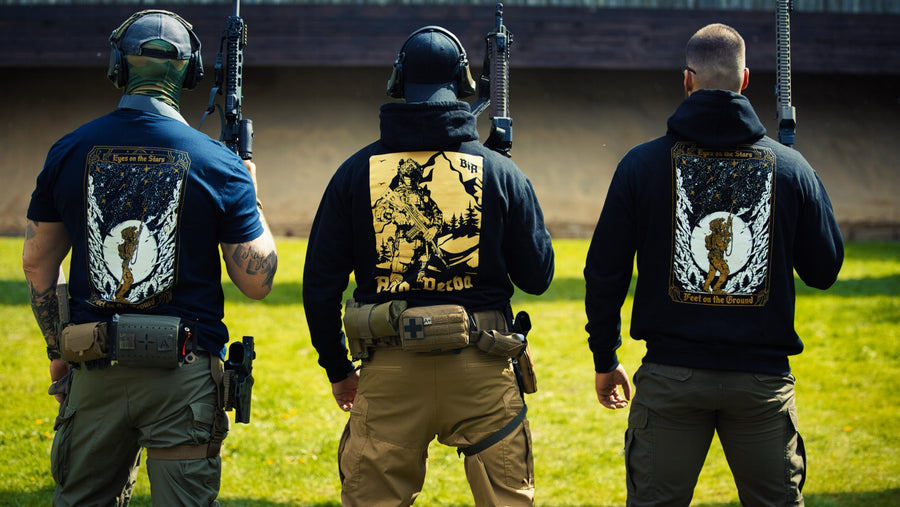Three shooters seen from behind at a range, wearing Brothers in Arms T-shirts and hoodies with large back prints