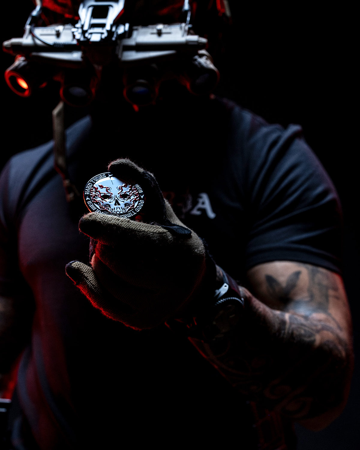 Operator holding the Hard Times coin in a gloved hand in low light