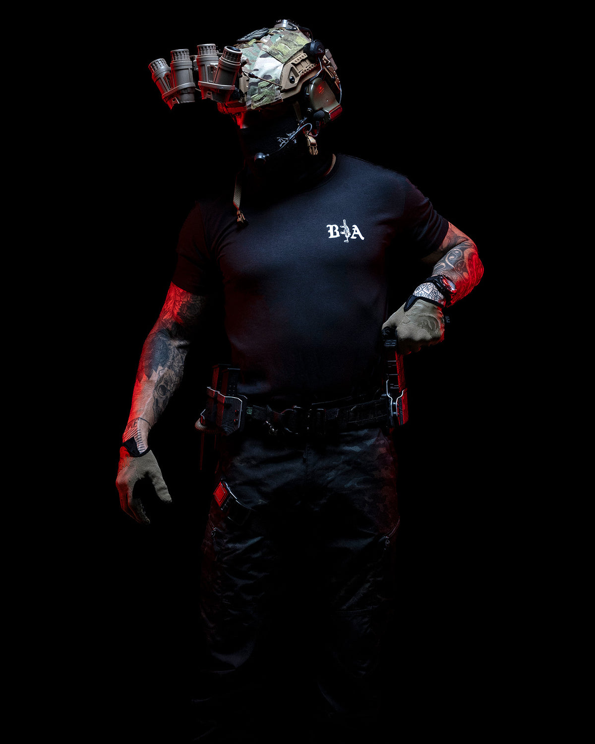 Man with helmet and face mask in the black Hard Times T-Shirt, lit red in the dark