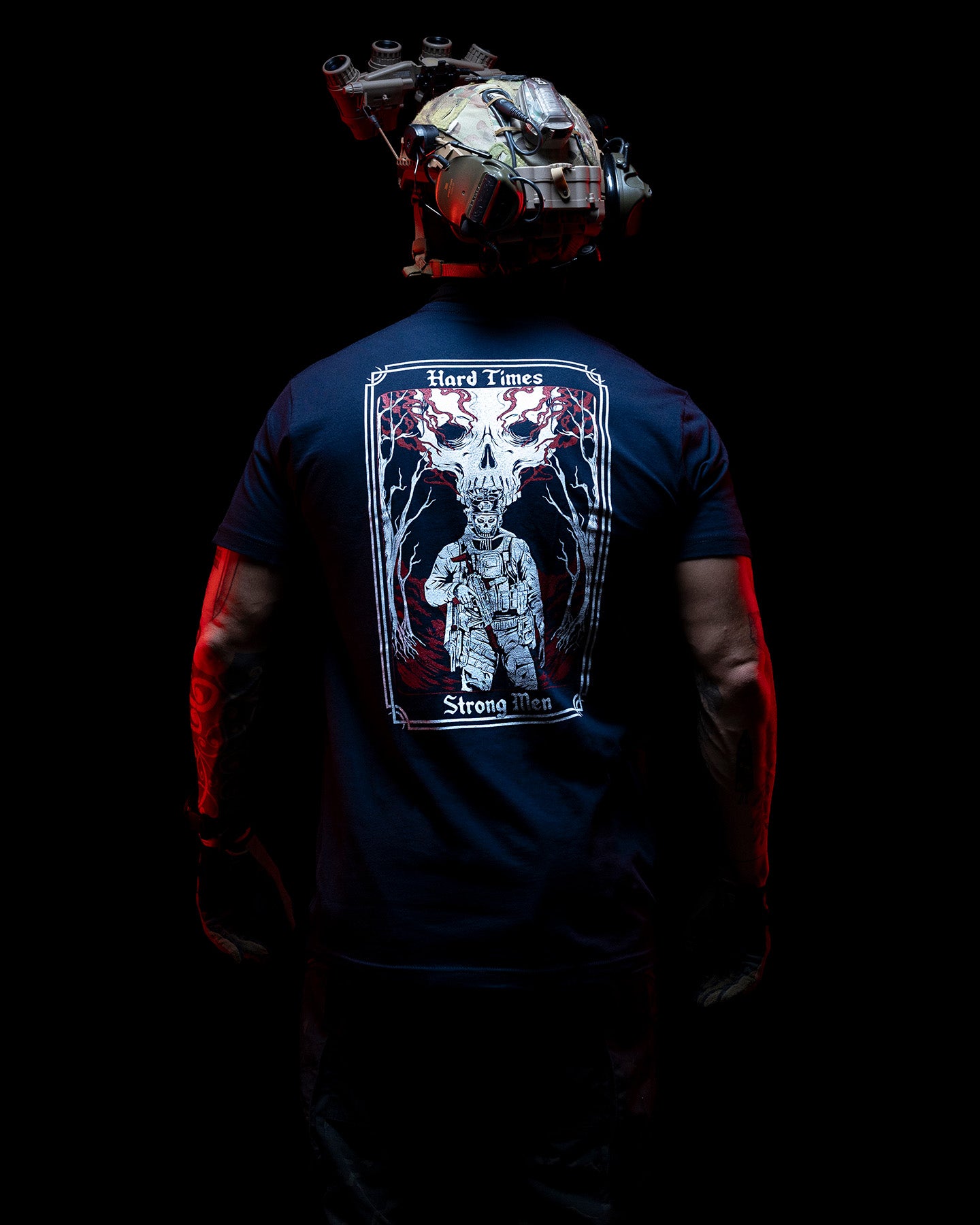Man from behind in the navy Hard Times T-Shirt showing the back print in low light #color_navy #in_field
