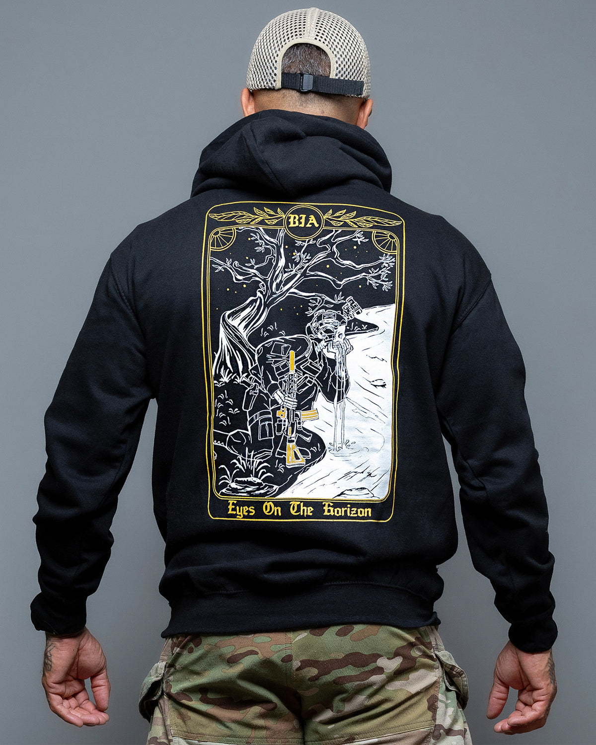 Man from behind in the black Eyes On The Horizon Hoodie with the tarot card back print