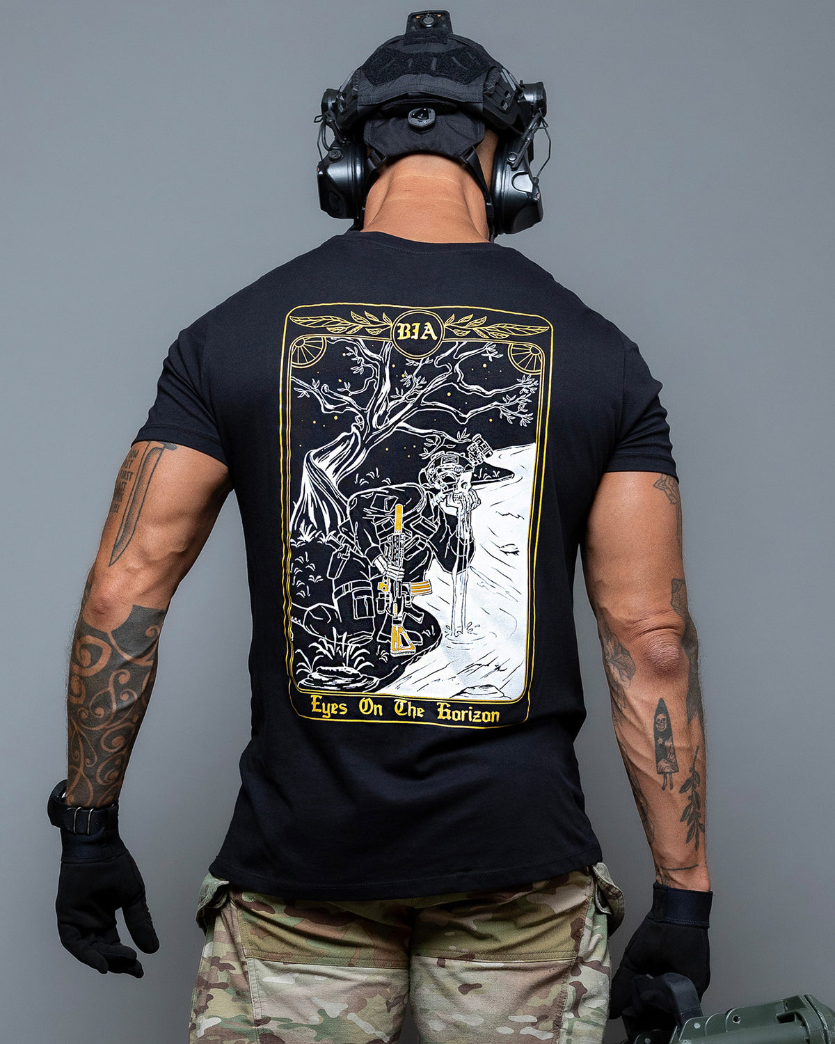 Man from behind in the black Eyes On The Horizon T-Shirt with the tarot card back print