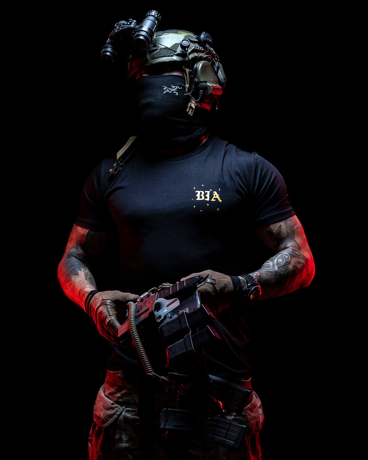 Operator with helmet and face mask in the black Eyes On The Horizon T-Shirt, lit red
