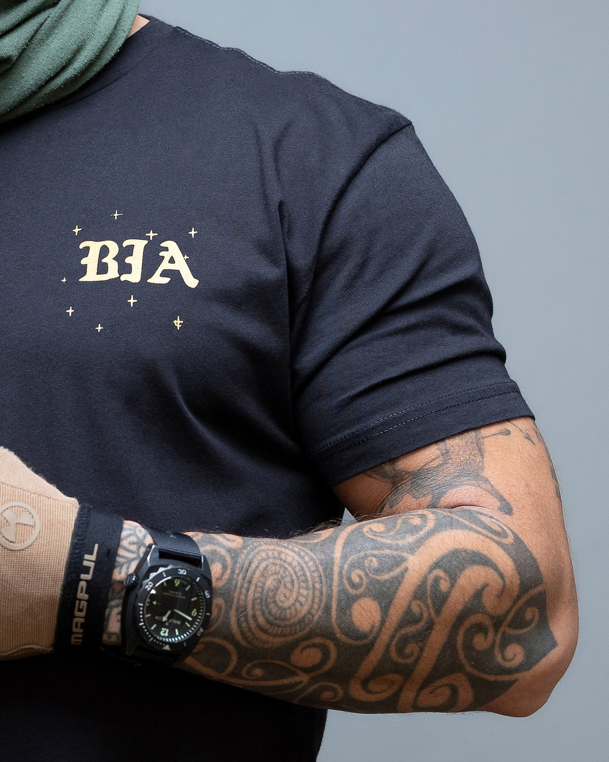 Close-up of the gold BIA chest print on the black Eyes On The Horizon T-Shirt