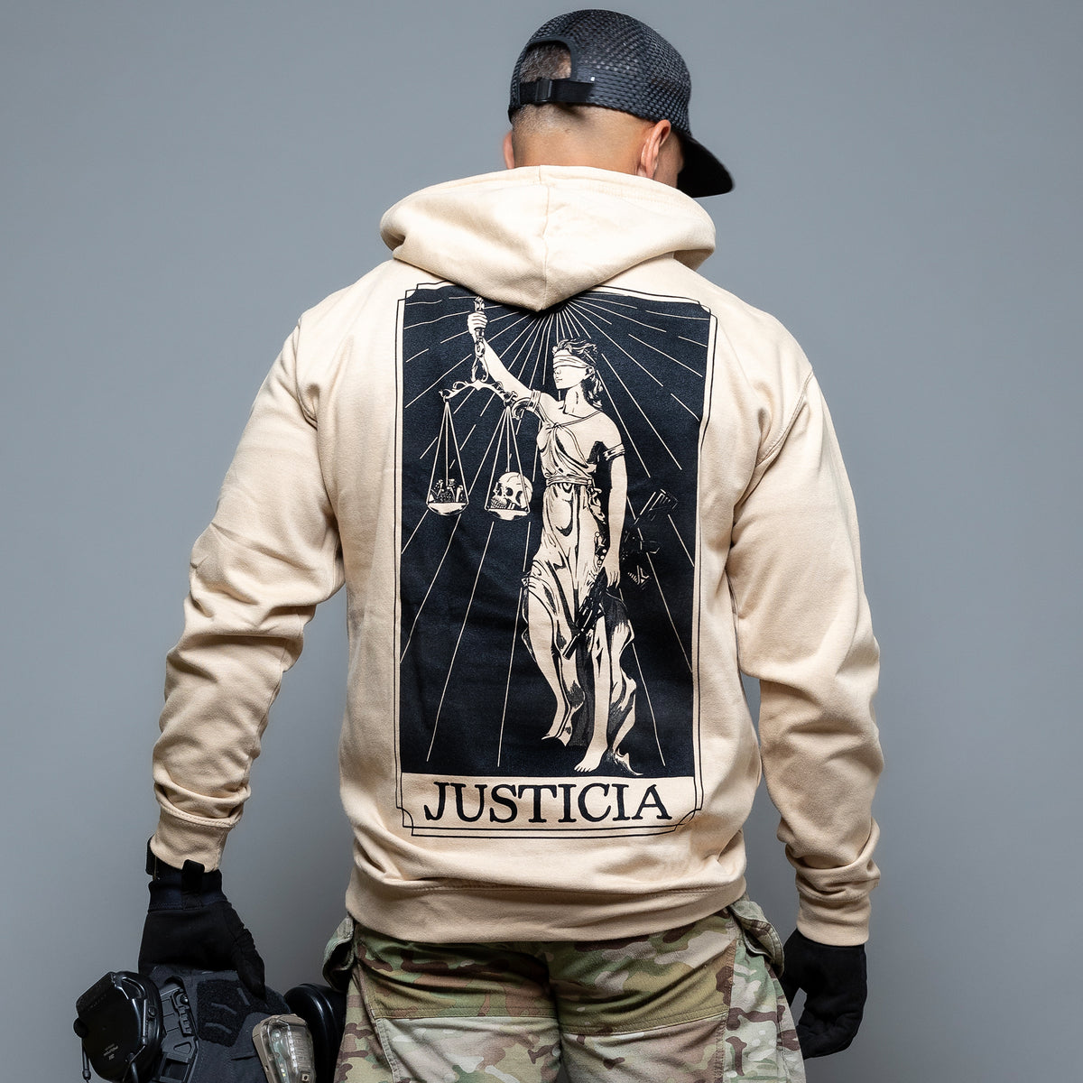 Rear view of the sand Justicia Hoodie with the Lady Justice back print