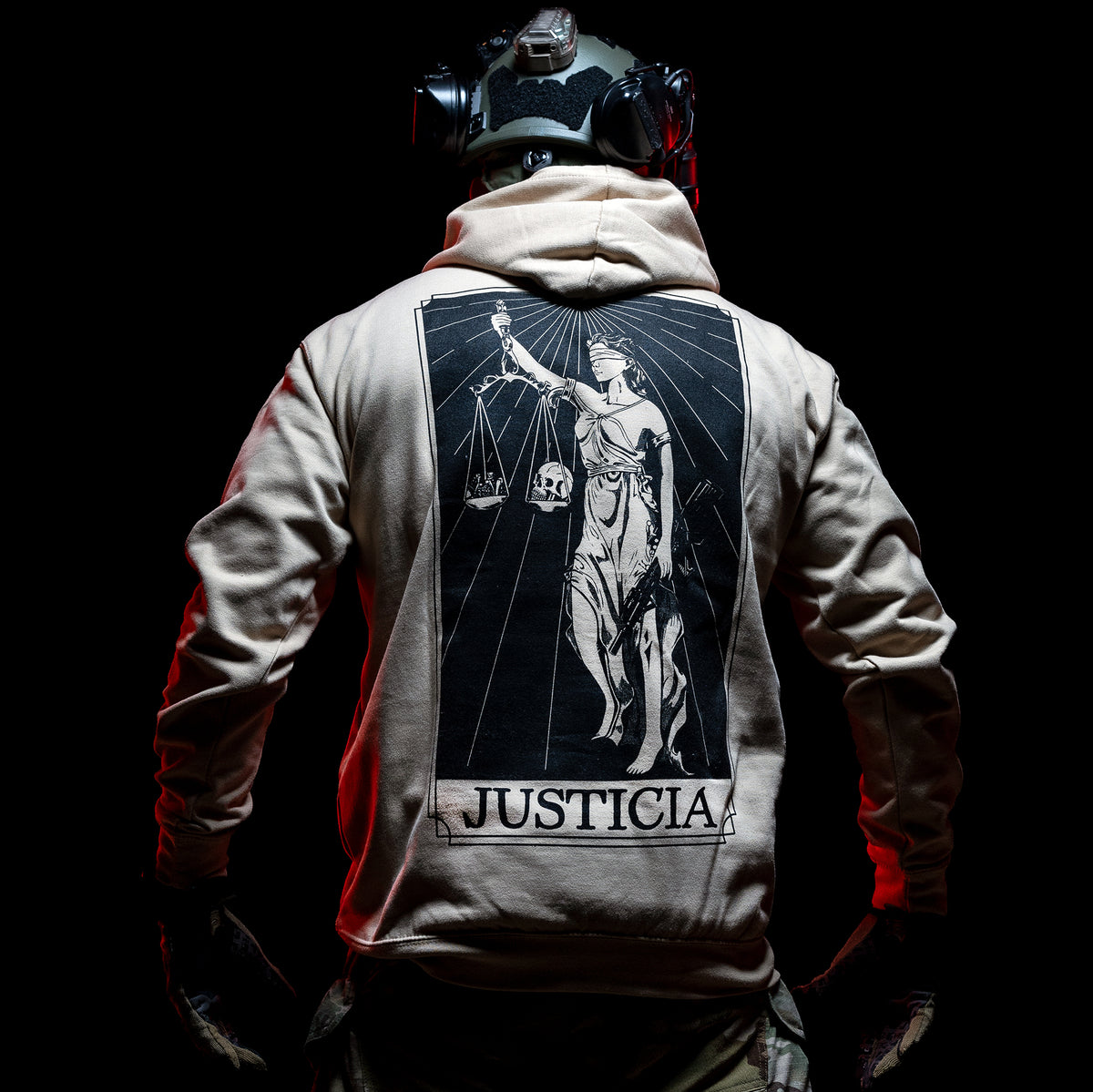 Man from behind in the sand Justicia Hoodie with the Lady Justice back print, lit red