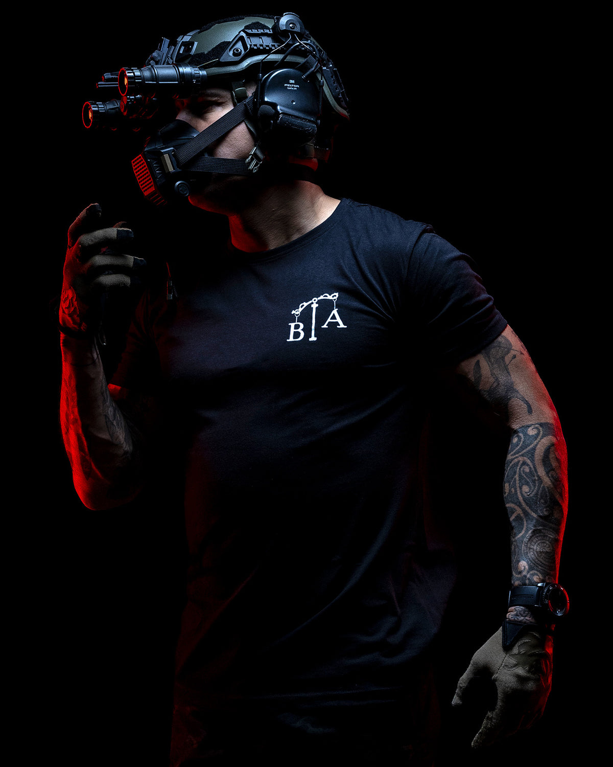 Operator with helmet and night vision in the black Justicia T-Shirt, lit red