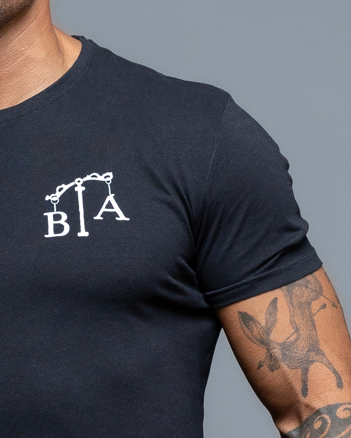 Close-up of the B|A chest logo on the black Justicia T-Shirt