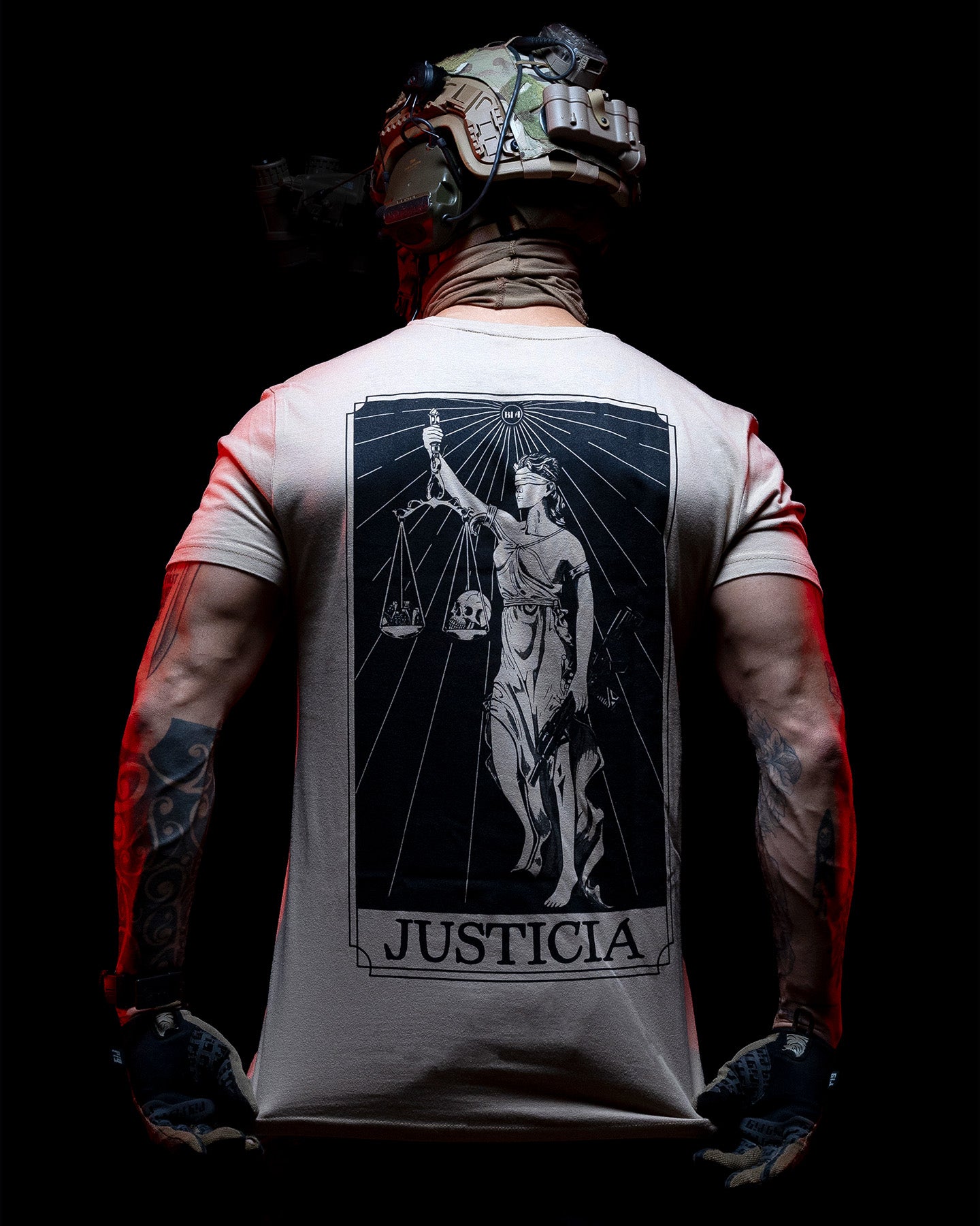 Man from behind in the sand Justicia T-Shirt with a helmet, back print lit red #color_sand #in_field