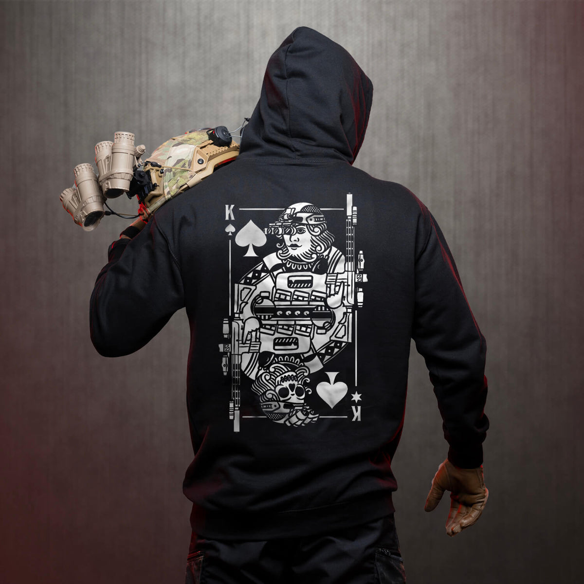 Man from behind in the black King of Spades Hoodie carrying a helmet over his shoulder