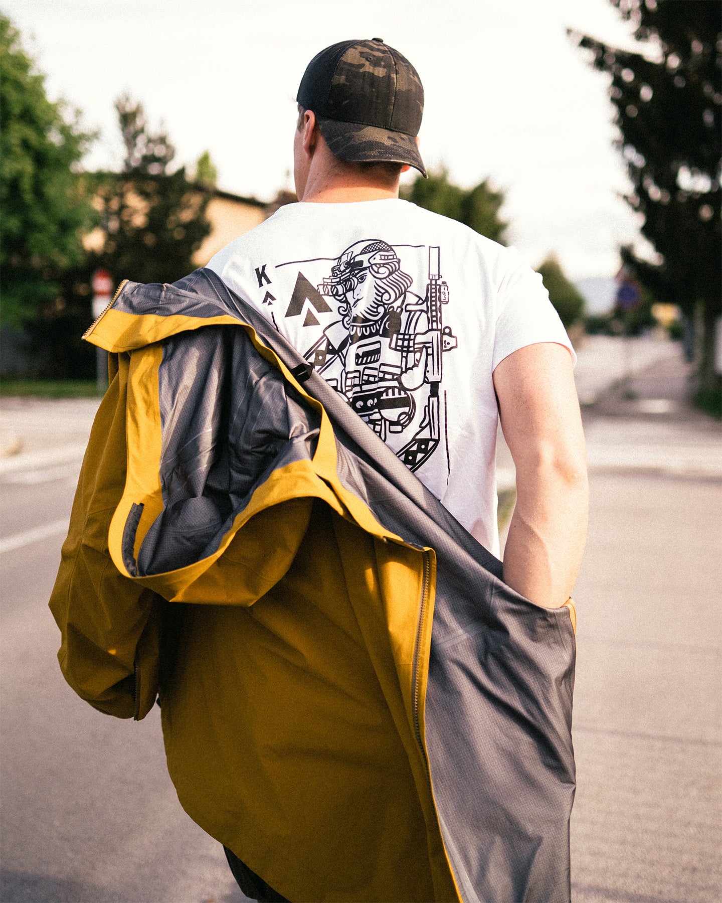 Man from behind with a jacket over his shoulder, wearing the white King of Spades T-Shirt #color_white #in_field