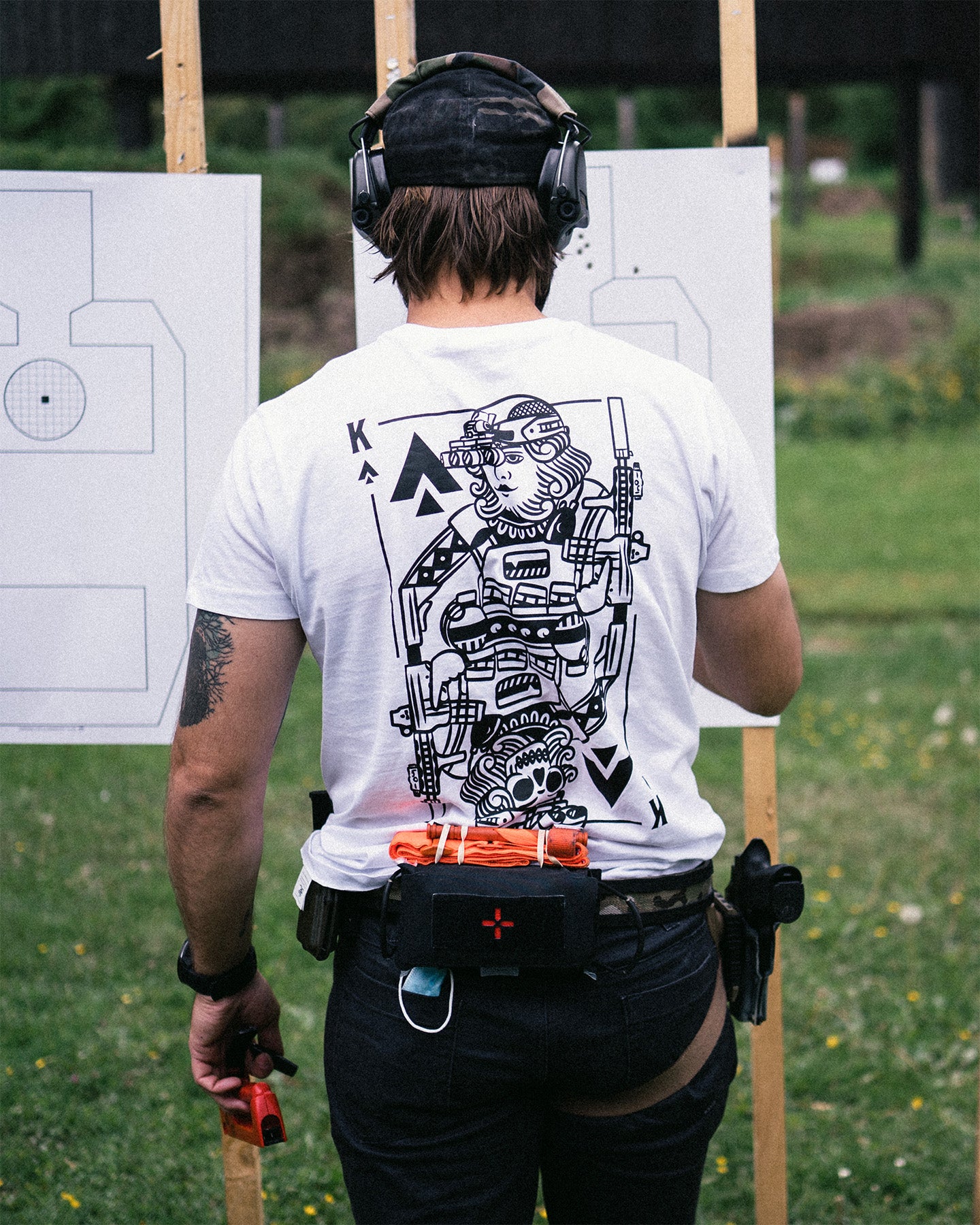 Person shooting at an outdoor range from behind in the white King of Spades T-Shirt #color_white #in_field
