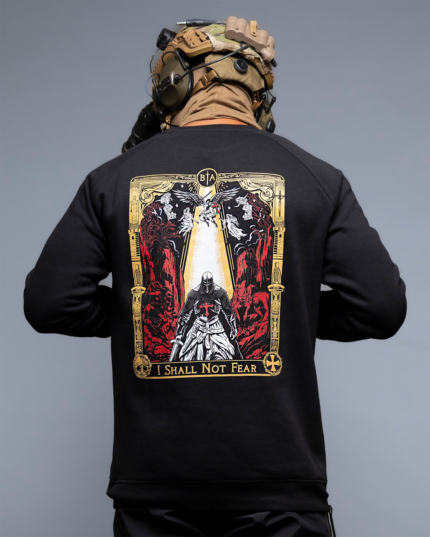 Person wearing a black long-sleeve shirt with a graphic design on the back, featuring text and imagery. #color_black