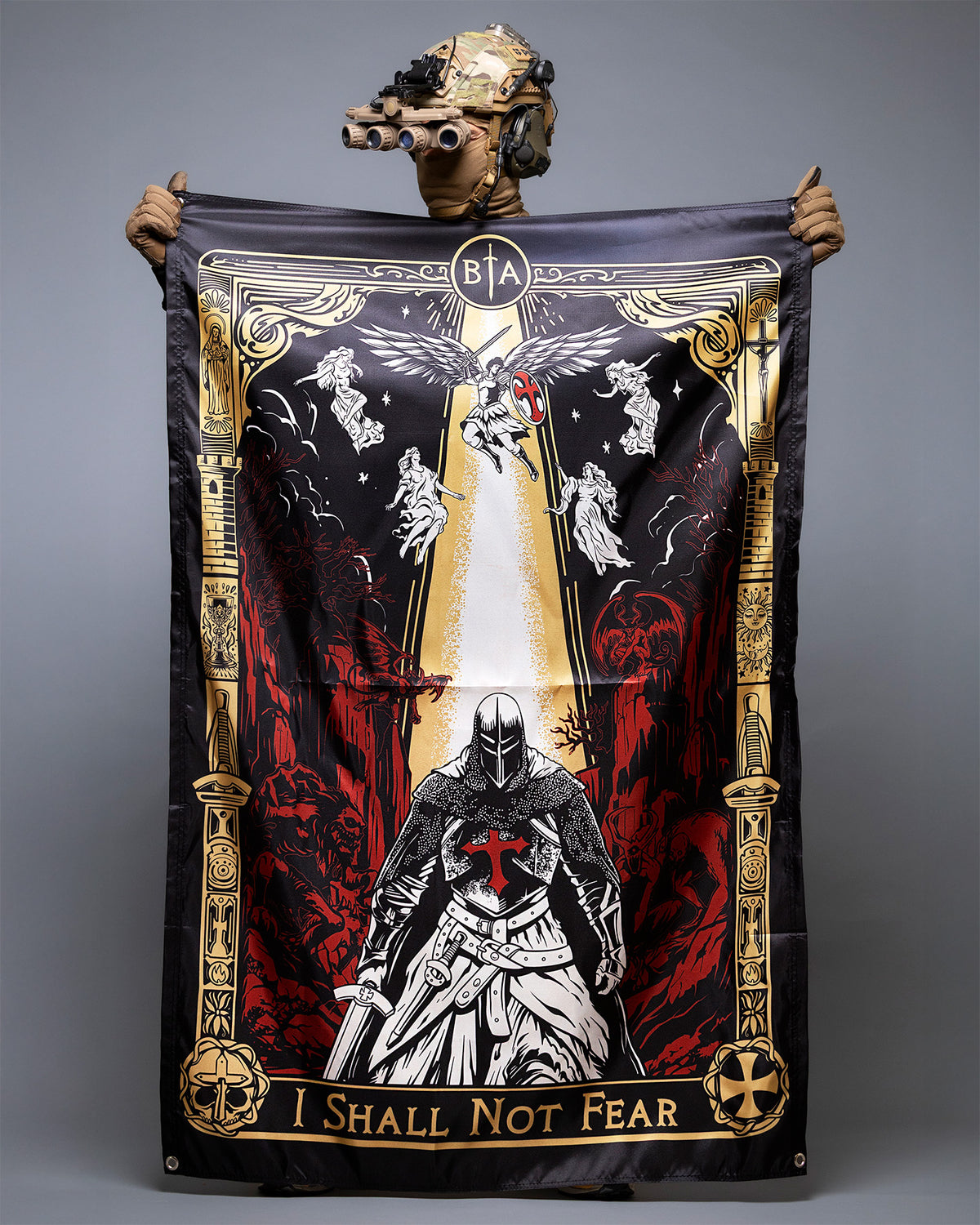 Person in a helmet holding up the I Shall Not Fear flag with the knight and angel artwork