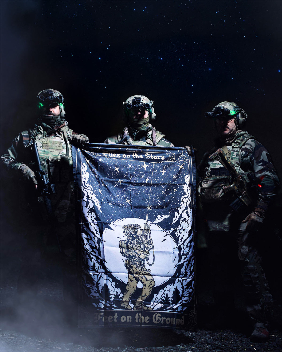 Three soldiers holding the Eyes On The Stars flag outdoors