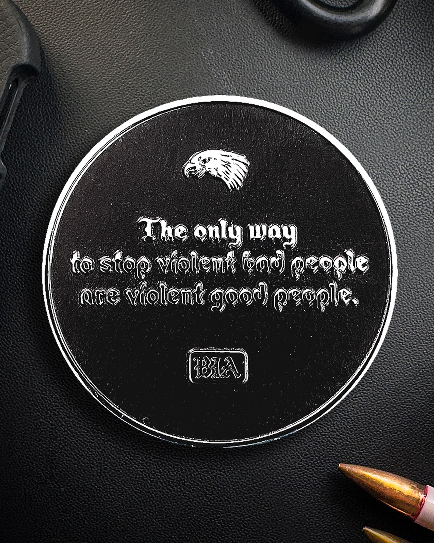 Circular metal Coin with engraved text and logo on a black surface
