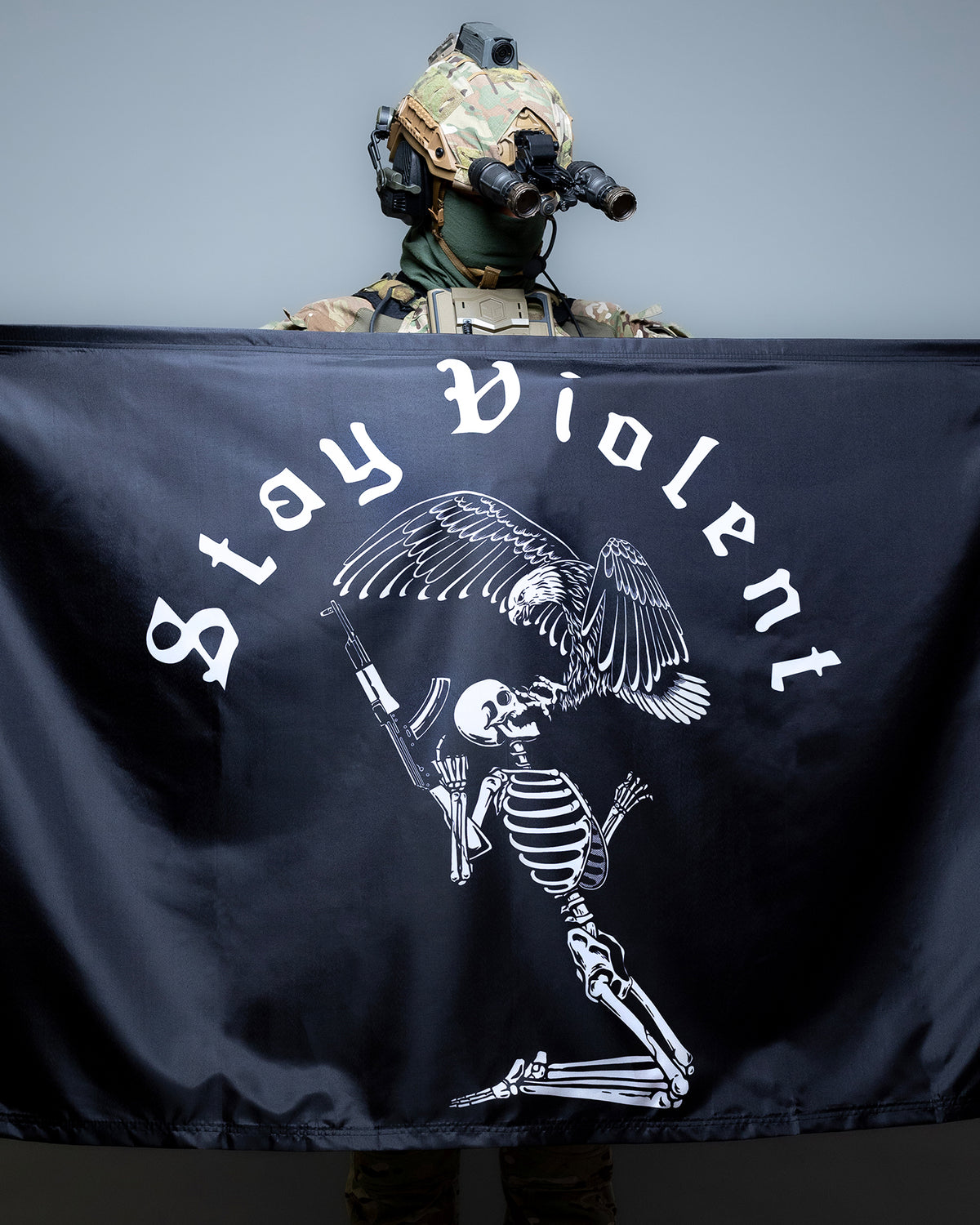 Operator holding up the Stay Violent flag with the skeleton artwork