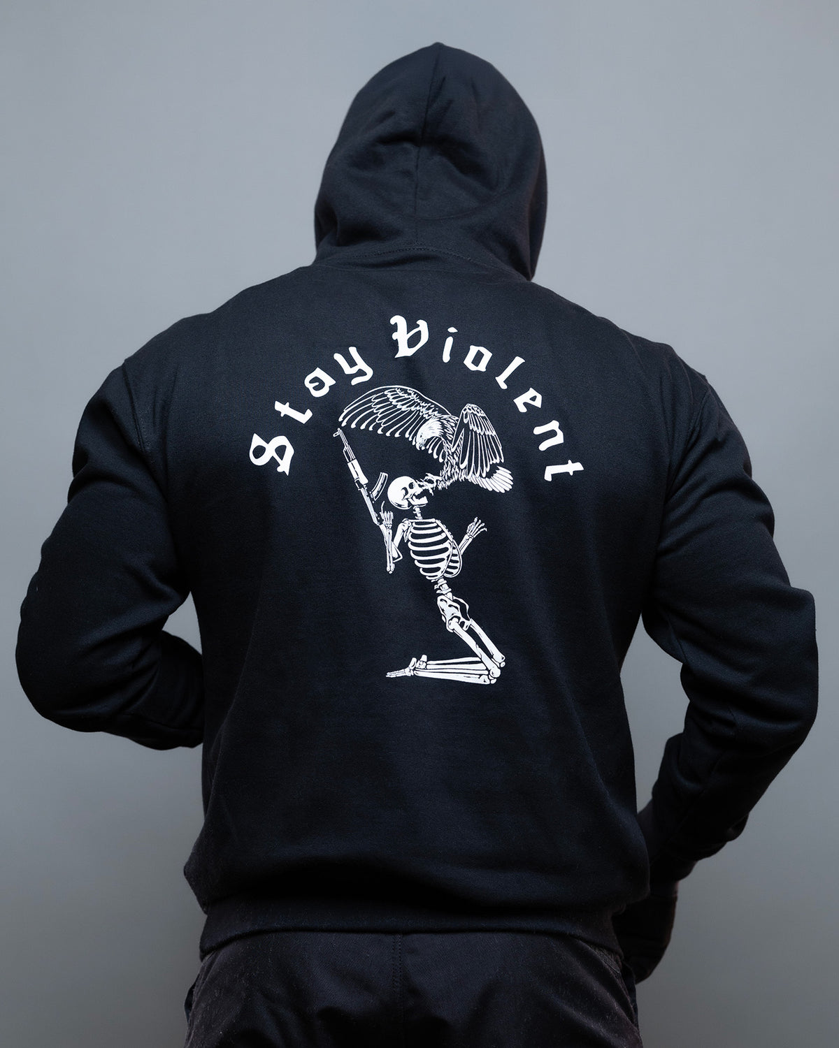 Man from behind in the black Stay Violent Hoodie, hood up, with the skeleton back print