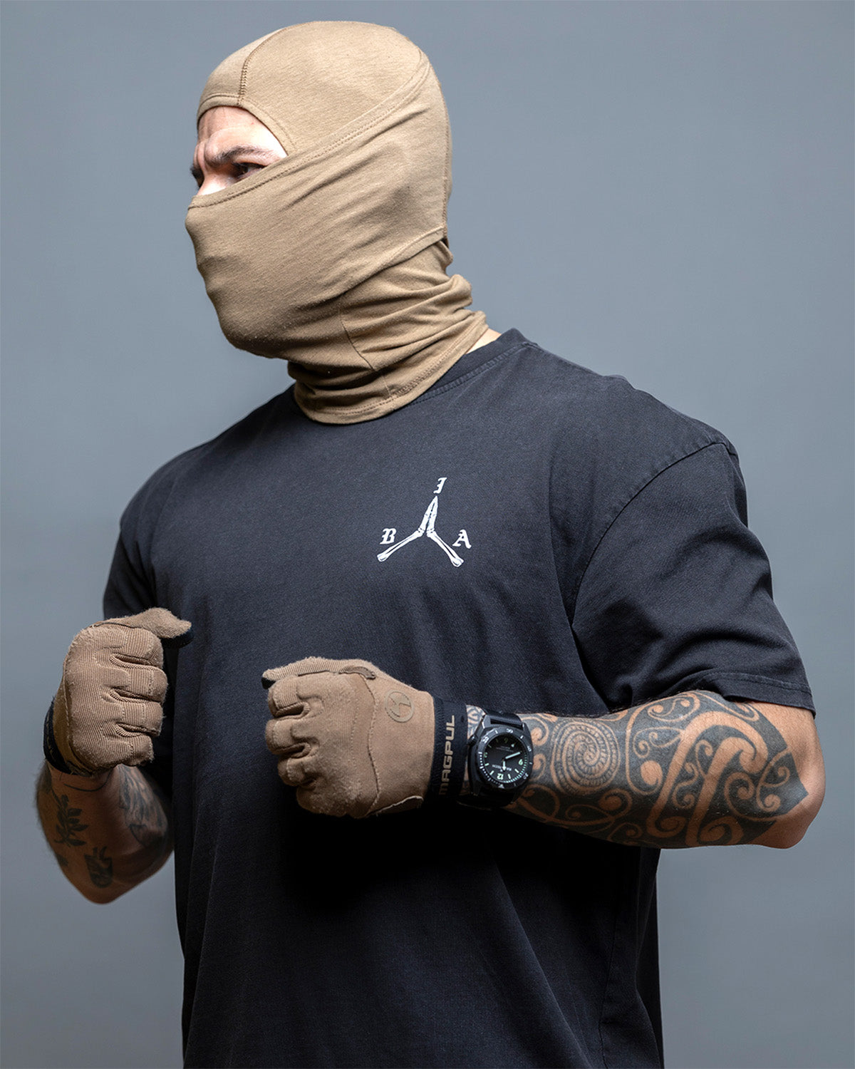 Close-up of a man in a balaclava wearing the black Stay Violent Oversized Shirt
