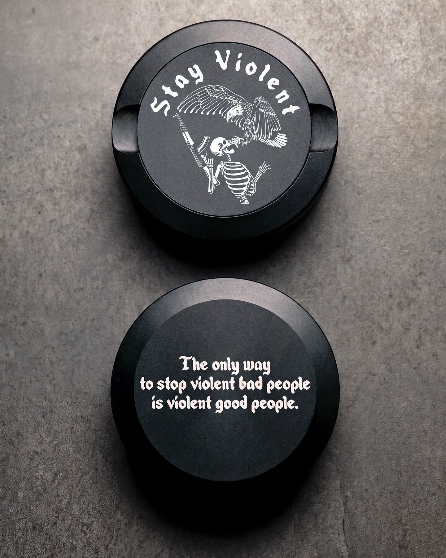 Two black Pouch Cans with the text "Stay Violent" and a skeleton design on a textured surface