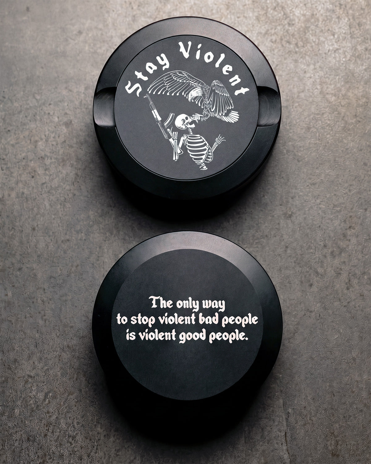 Two black Pouch Cans with the text "Stay Violent" and a skeleton design on a textured surface