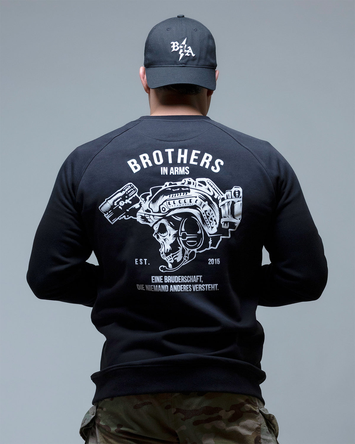Man from behind in the black Team crewneck showing the Brothers in Arms back print
