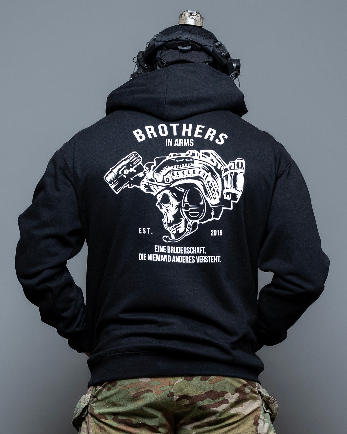 Man from behind in the black Team Hoodie with the skull and helmet back print
