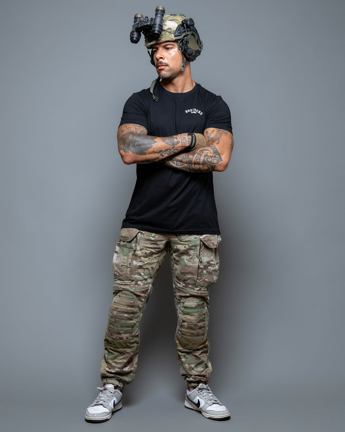 Full-length shot of the black Team T-Shirt worn with camo trousers and a helmet